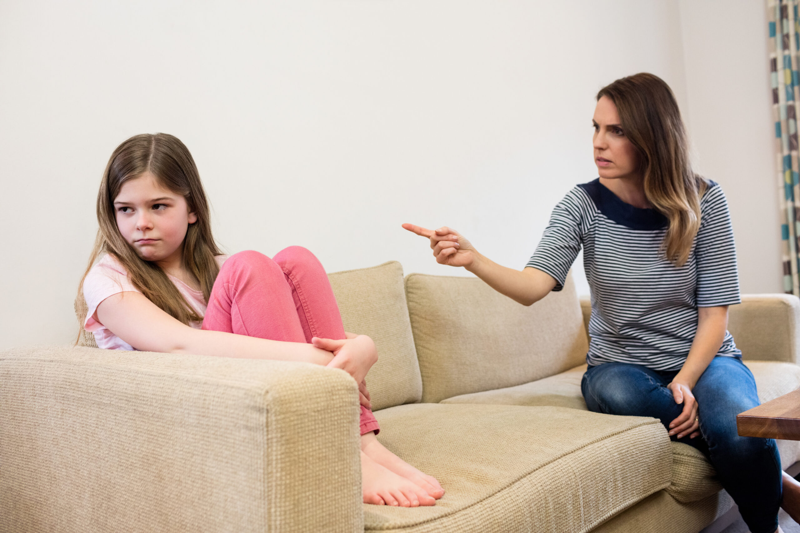 Daughter ignoring her mother after an argument in living room at home